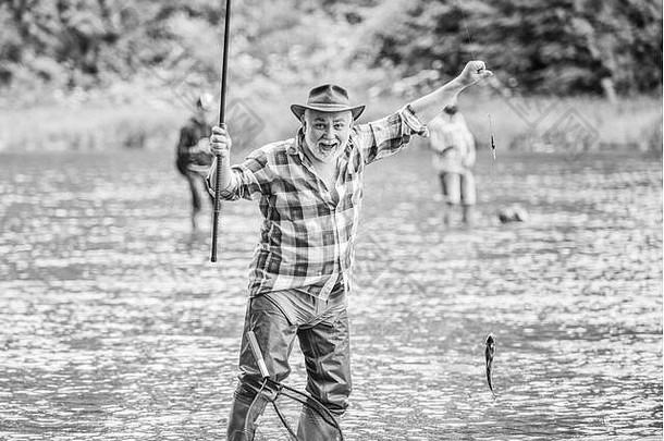 最好的时刻。成熟男子钓鱼。夏季周末。拿着鱼竿的渔夫。波特亨特。有人在抓鱼。退休的胡子渔夫。大型钓鱼。体育活动和爱好。鳟鱼饵。