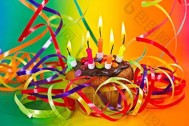 生日蛋糕色彩斑斓的彩带装饰燃烧蜡烛