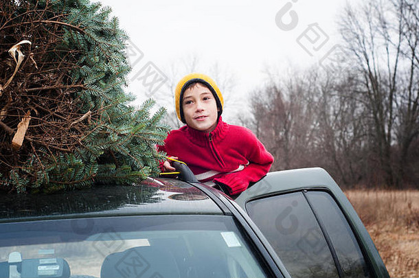 车顶上有<strong>圣诞</strong>树的小男孩