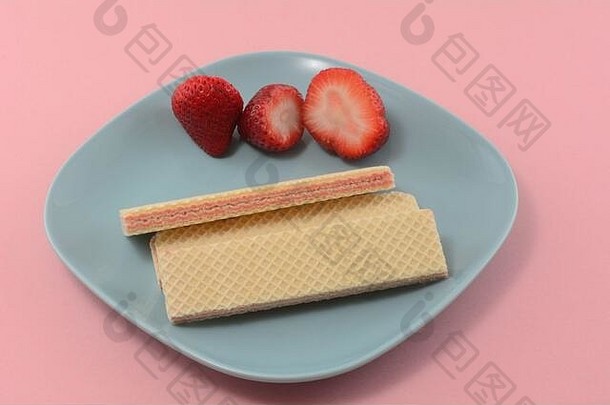 草莓糖晶片饼干新鲜的生草莓蓝色的零食板粉红色的背景