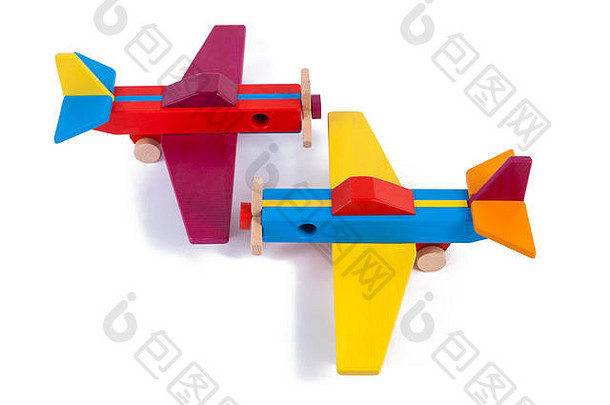 从山毛榉拍摄的两架木制多色飞机的照片。白色背景上的玩具木复古飞机