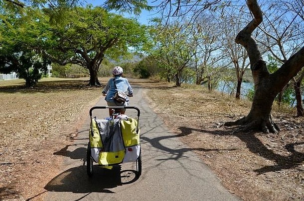 澳大利亚昆士兰州汤斯维尔，一名妇女骑着一辆儿童自行车拖车