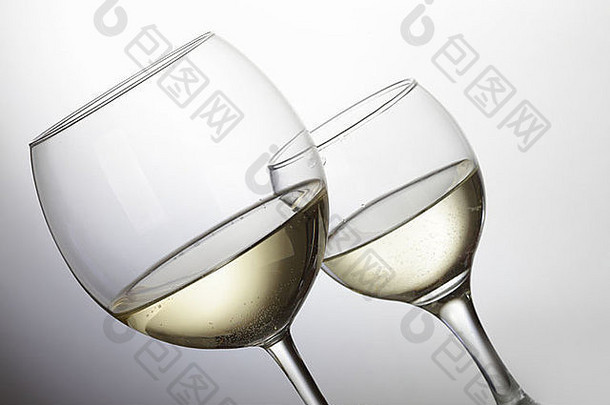 浅灰色背景上的两杯白葡萄酒