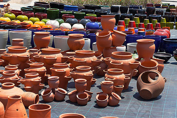 市场上五彩缤纷的陶瓷壶，阳光明媚