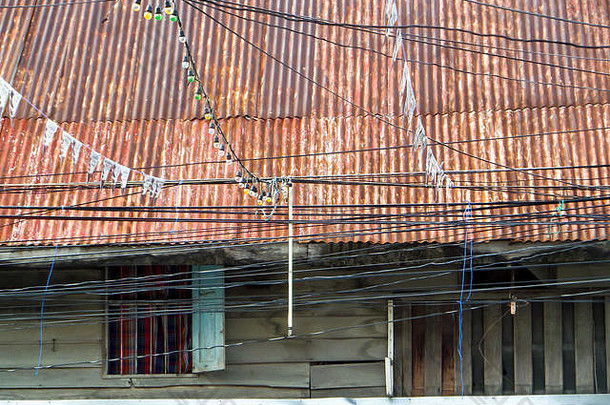 旧式木质古宅，屋外锈蚀屋顶及电力线路