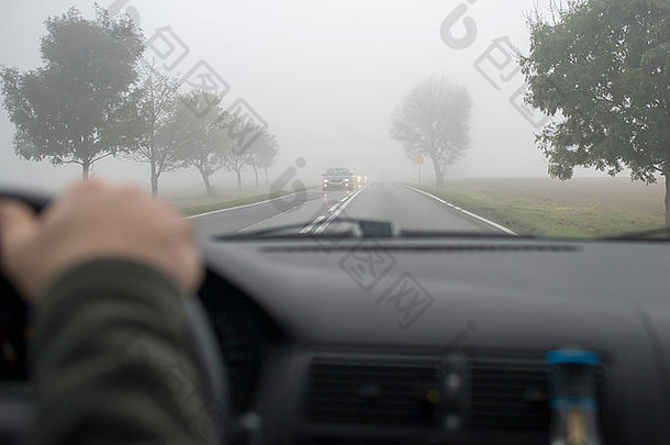在浓雾中行驶的汽车，通过其他车辆的挡风玻璃看到
