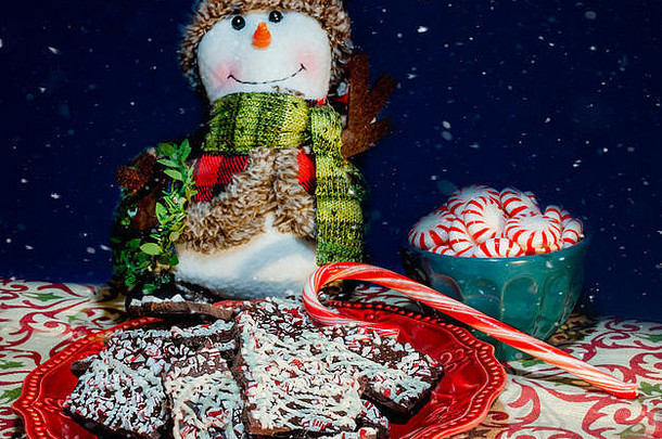 2018年12月31日，在阿拉巴马州的科登，一个雪人旁边的红盘子上摆着黑巧克力薄荷树皮糖。