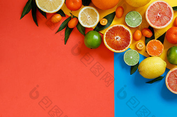 红色、黄色和蓝色背景顶视图上的柑橘类水果