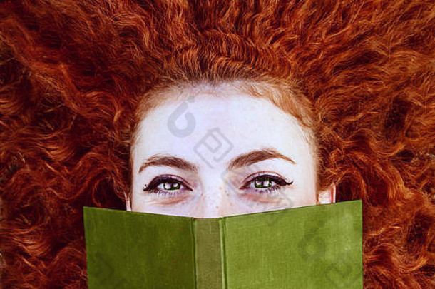 年轻的红色头发的人女人阅读书