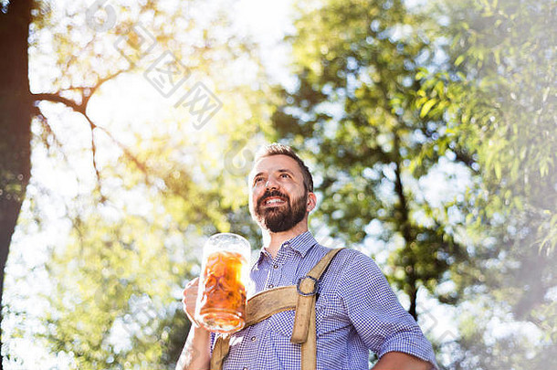穿着巴伐利亚传统服装的男子手持啤酒杯