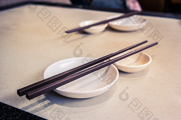 桌子上放着筷子的空盘子。