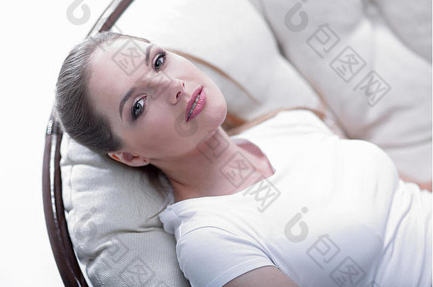 疲惫的女人在藤条制成的安乐椅上休息