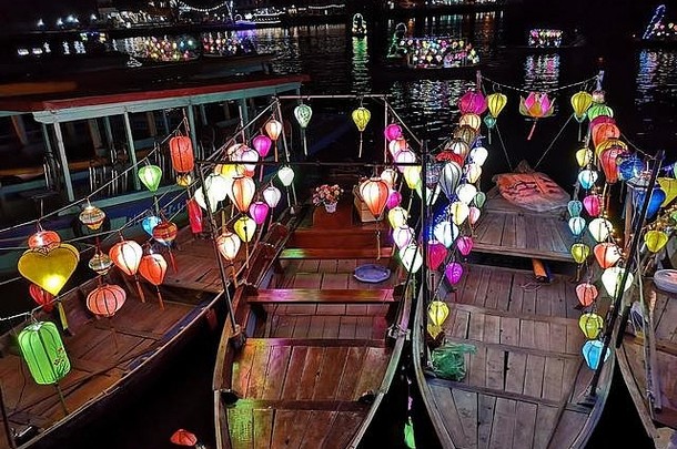 越南海安古镇河岸附近挂在木船上的彩灯夜景