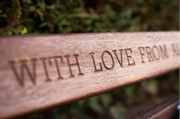 在板凳上的木头上雕刻《带着爱》