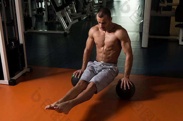 作为健身房健身训练的一部分，运动员在健身球上做倒立俯卧撑