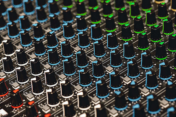 专业混音器。录音室中用于声音调节的彩色控制按钮的特写视图。音响设备。唱片服务