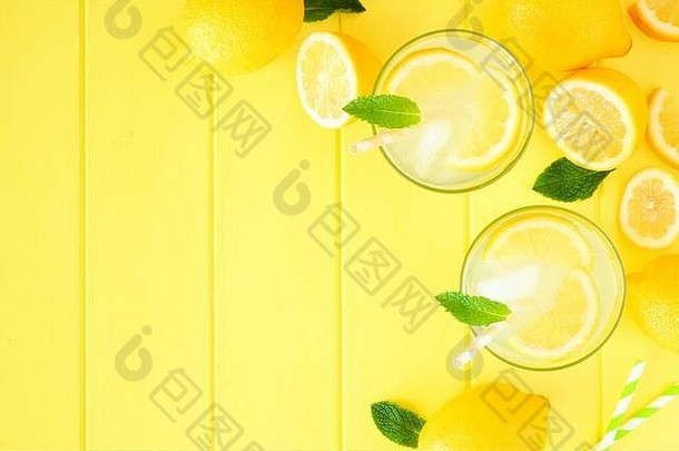 甜甜的夏日柠檬水。顶视图角边框，亮黄色木质背景上有空间。