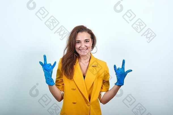 迷人的女人黄色的夹克有趣的蓝色的手套岩石手势音乐