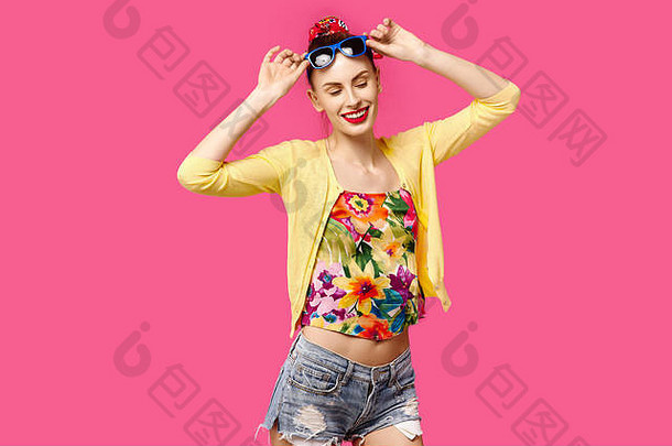 年轻的美丽的女孩黄色的毛衣太阳镜粉红色的背景笑颜色痴迷概念简约风格时尚的时尚的
