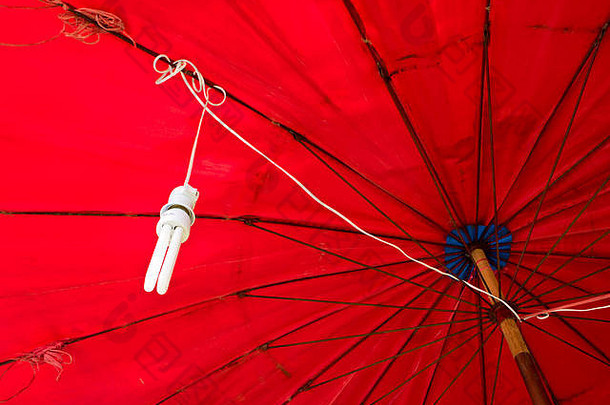 悬挂在红色伞下的紧凑型荧光灯