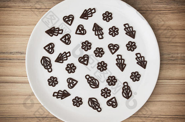 大盘子里装饰着黑巧克力。甜食。符号形状。创意美食。糖果主题。