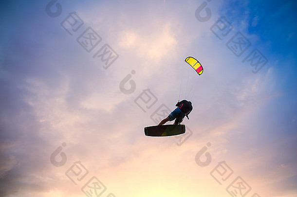 风筝爱好者在日落时向天空跳跃