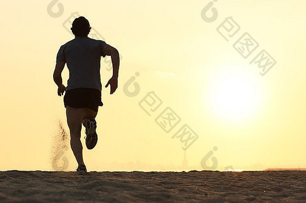 回来视图轮廓跑步者男人。运行海滩日落太阳背景