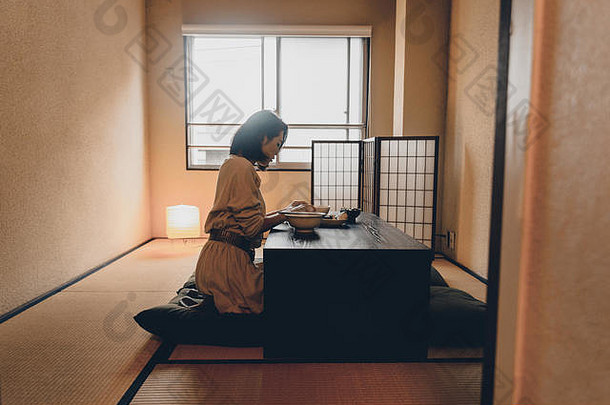 在东京一间传统的日本公寓里吃饭的亚洲女人