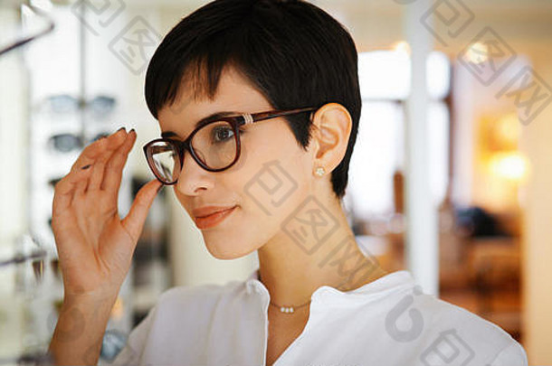 漂亮的年轻的女人选择眼镜光学商店