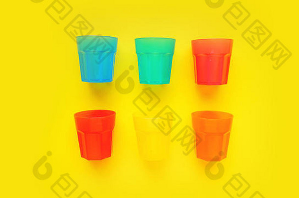 黄色背景上隔离的各种颜色的塑料玻璃-设计和横幅的明亮夏季概念