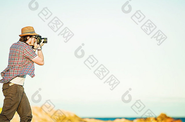 年轻的摄影师采取照片海滩