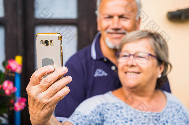 两位白发老人用手机自拍。夫妻白种人