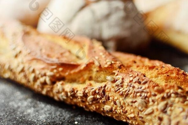 放在柳条篮中的烘焙产品。圆面包、带种子的长面包、不含酵母的纯<strong>素面</strong>包。木质背景