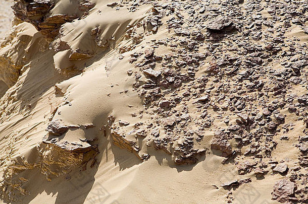在前往埃及吉尔夫·凯比尔的途中，撒哈拉沙漠岩石和沙子纹理的特写镜头。