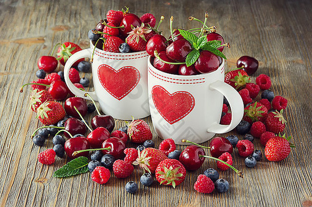 成熟的浆果樱桃树莓蓝莓杯夏天收获新鲜的维生素古董背景