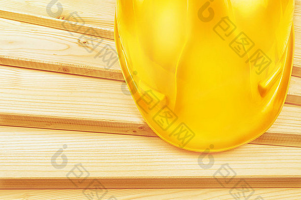 松木木板上的黄色安全帽，作为木工作业概念的空间
