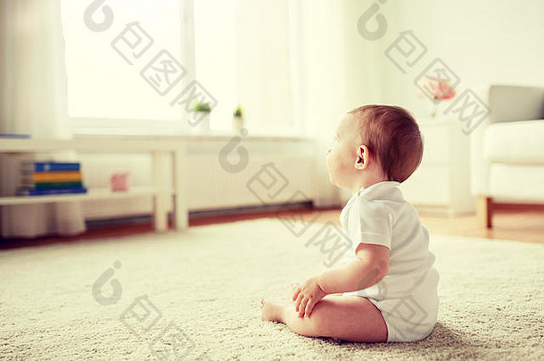 快乐的小男孩或小女孩坐在家里的地板上