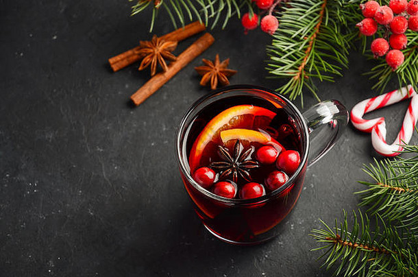 带有橘子和小红莓的圣诞节热葡萄酒。用冷杉枝和香料装饰的节日概念。