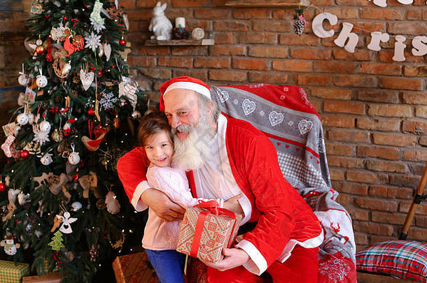 小女孩来到圣诞老人面前，送上<strong>新年</strong>礼物并拥抱他