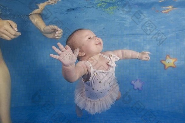 婴儿女孩学习游泳水下婴儿游泳水下池蓝色的水背景