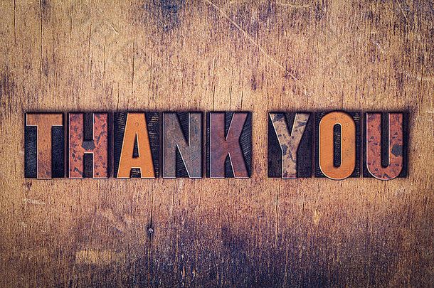 “谢谢你”这个词是用肮脏的老式活版印刷字体写在一个陈旧的木制背景上的。