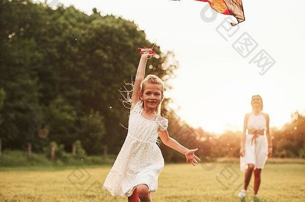 前视图。妈妈和女儿在田野里玩<strong>风筝</strong>。美丽的自然