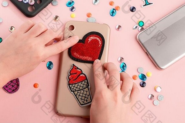 女孩把红心和冰淇淋贴在米色手机壳上