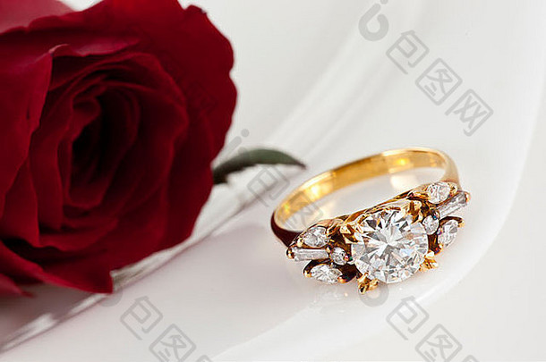 白底金色钻石戒指和玫瑰