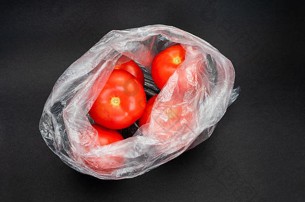 红色的西红柿透明的开放塑料袋灰色背景