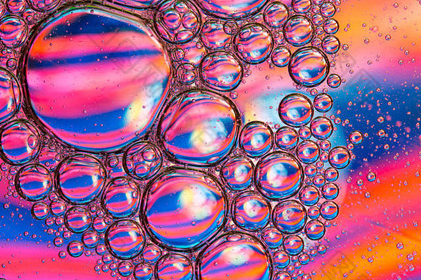 彩色背景下水面上植物油滴/气泡特写细节的抽象背景