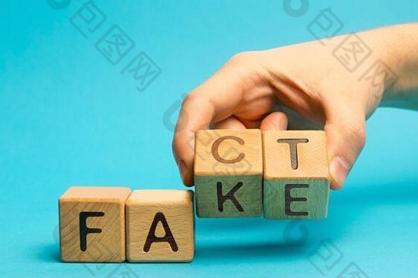一个男人在木块上写上“事实”和“伪造”。新闻和虚假信息的概念。黄色出版社。