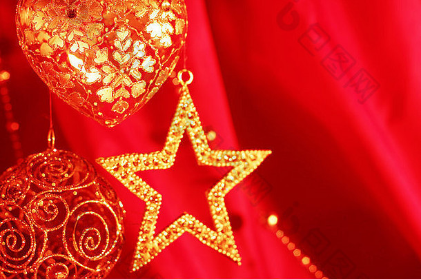 红色织物背景上的金色圣诞装饰