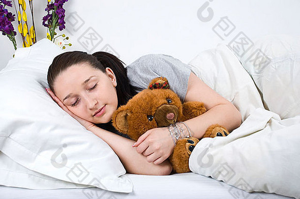 睡在床上拥抱泰迪熊的美女