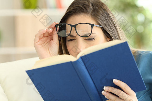 一名眼睛疲劳的妇女试图在家看书